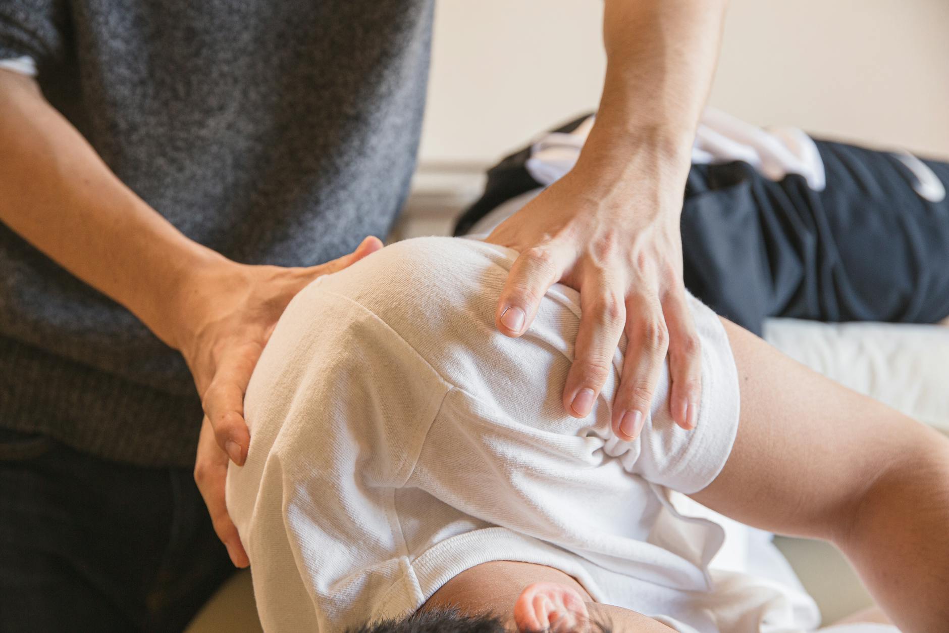 Chiropracteur en train de mobiliser l'épaule de la patiente; Douleurs a l'épaule.